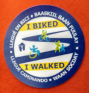 Closeup of sticker which says I biked I walked in several languages